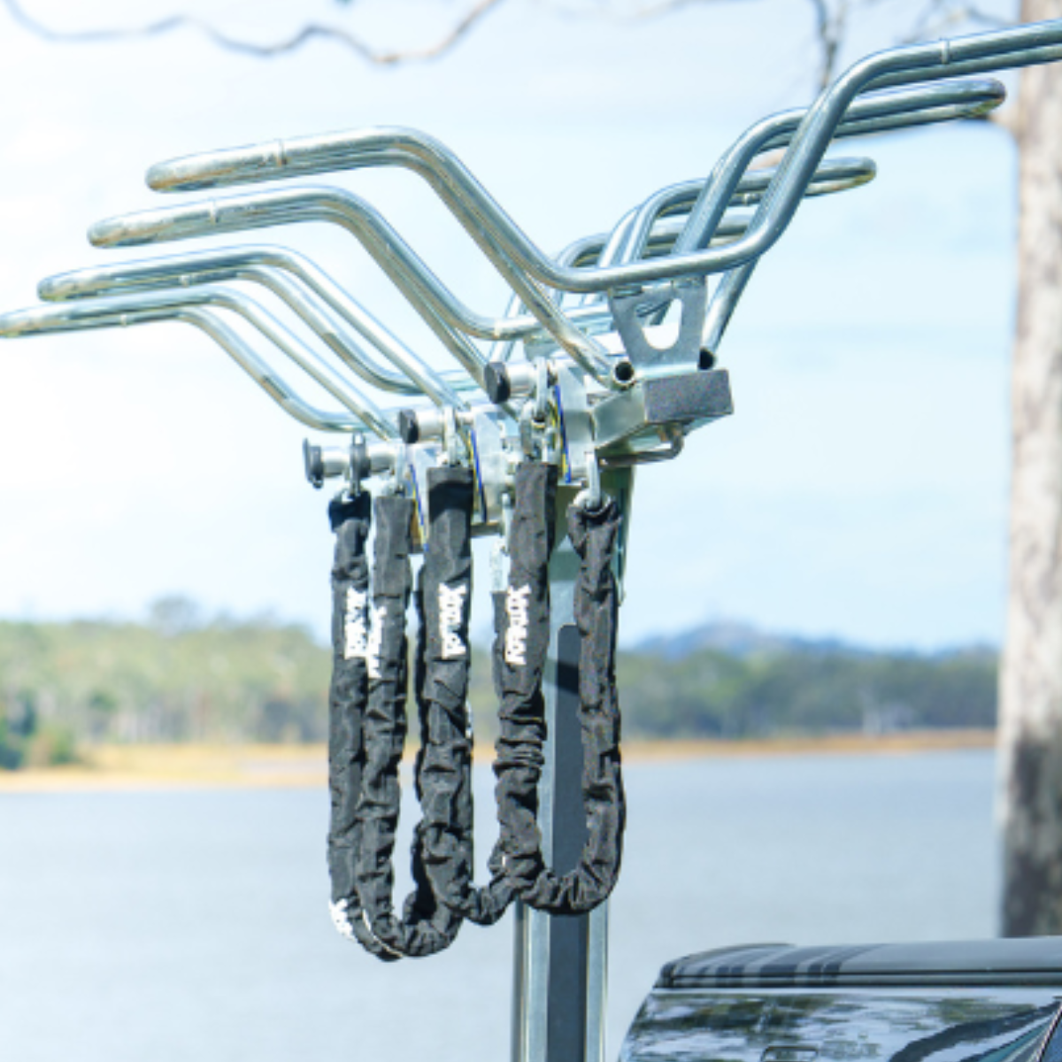 A vertical car rack with raklox chains attached, set against a scenic background.