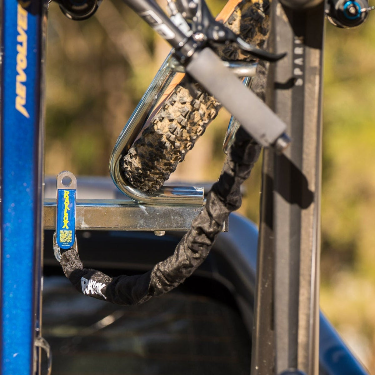 Close-up of a blue bicycle with a racklox secure anchor on a blurred natural background