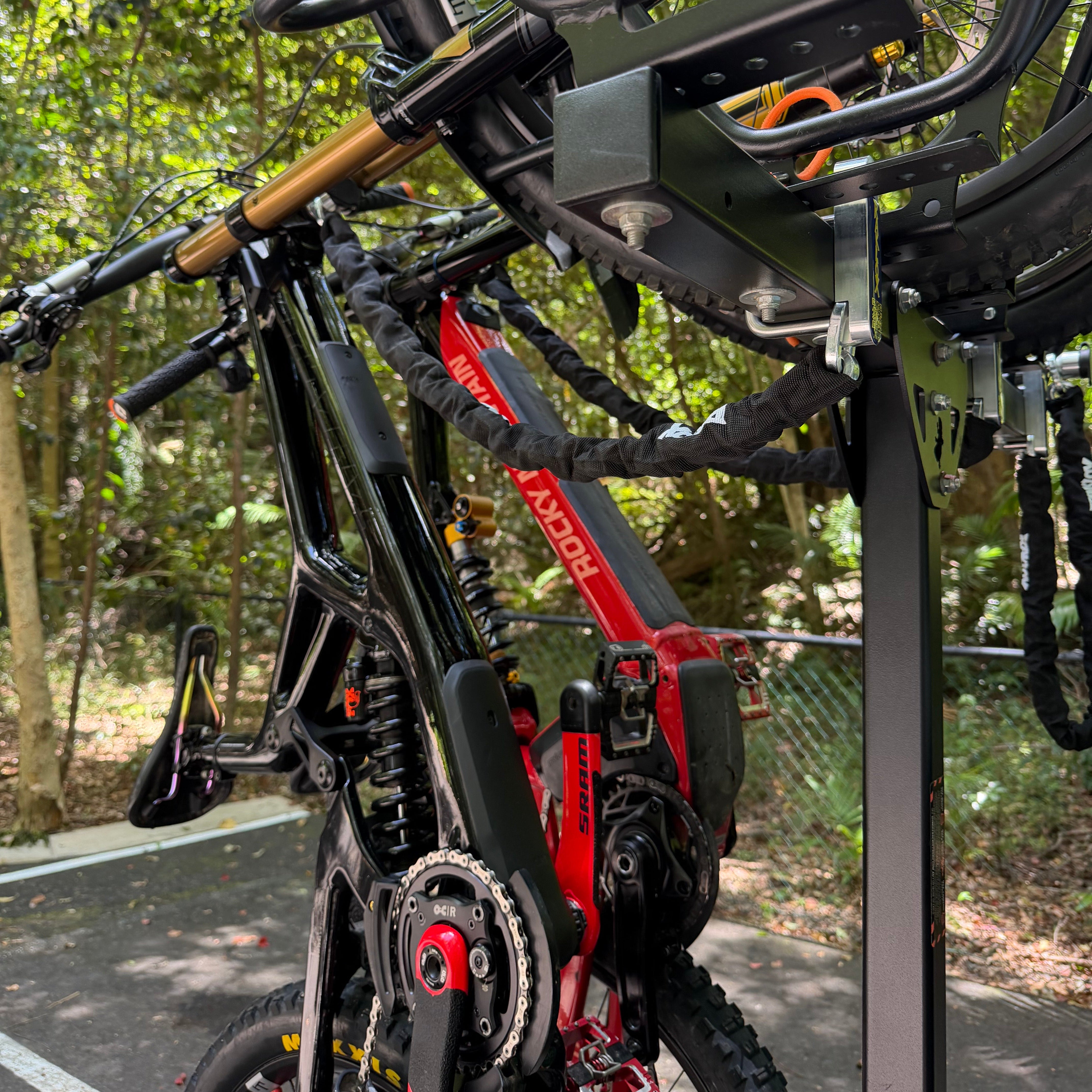 Close-up of a bicycle with a red frame on a vertical rack with secure anchor